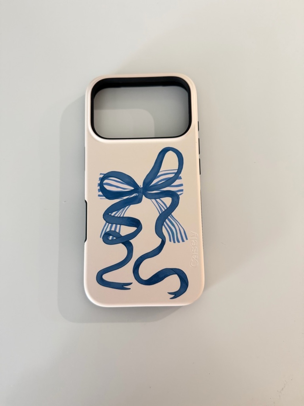 Casely White Phone Case with Blue Ribbon Design -  iPhone 17 pro